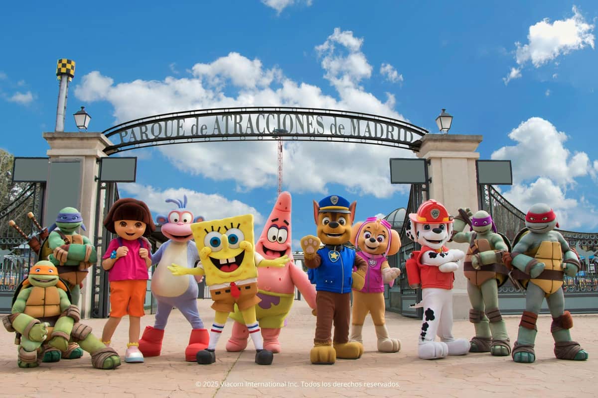 A group of cartoon character mascots, including a sponge, a starfish and a young explorer, posed at the entrance to an amusement park.