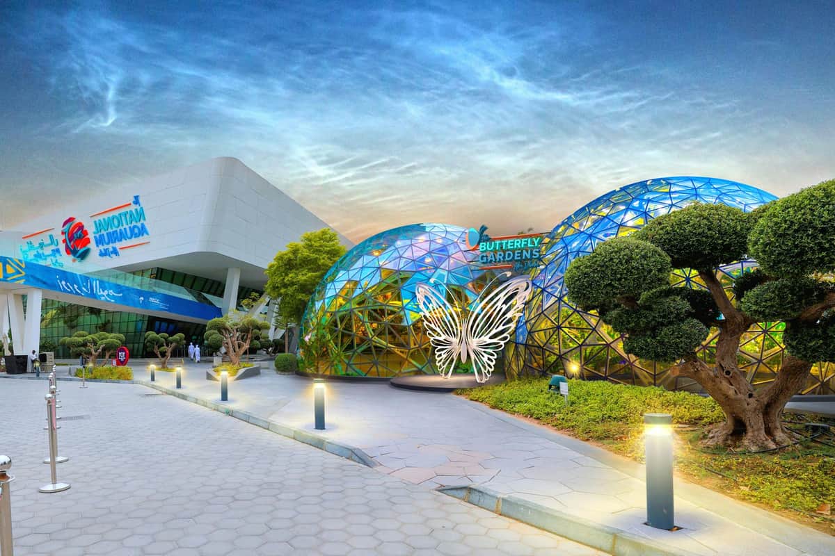 The Butterfly Gardens & The National Aquarium Abu Dhabi: Entry Ticket A modern building with dome-shaped structures labeled "Butterfly Gardens," featuring a decorative butterfly sign.