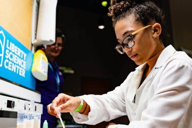 Girl doing lab work with a pipette.