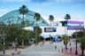 Vista exterior do Florida Aquarium, com uma estrutura de vidro, palmeiras e um céu azul claro.
